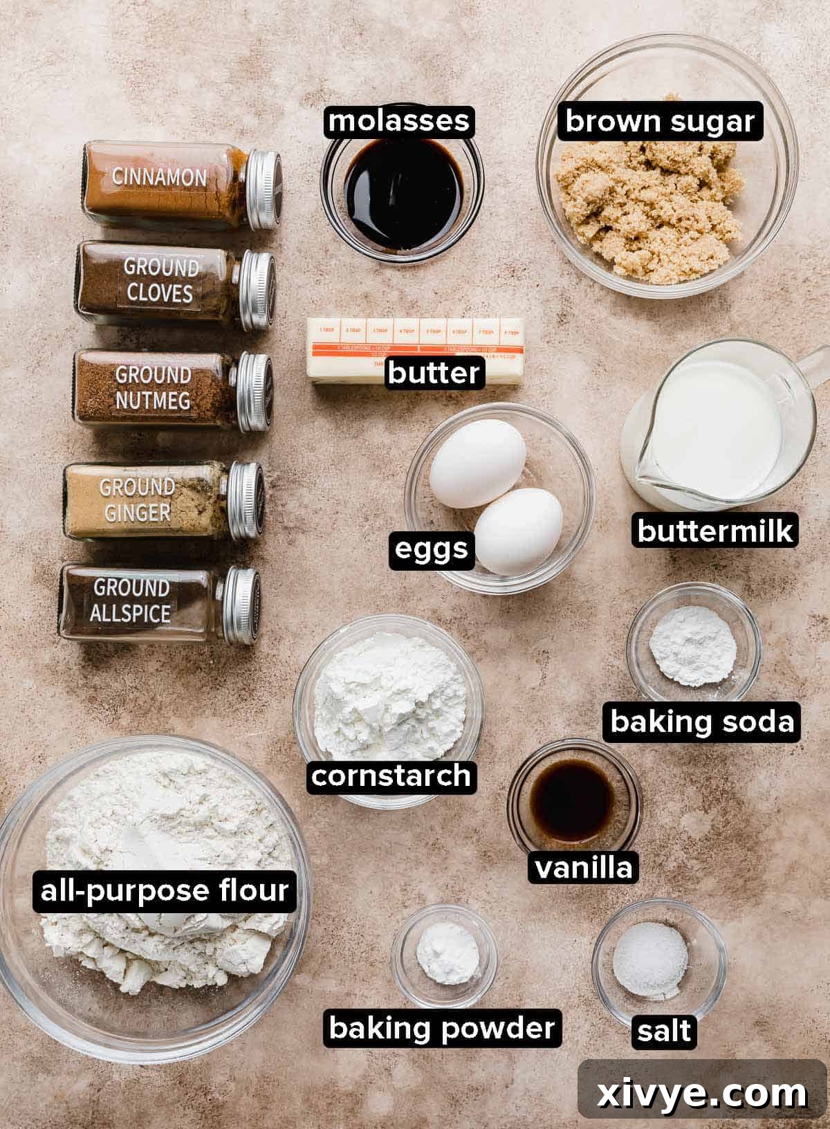 Gingerbread Waffle ingredients portioned into glass bowls on a light brown textured background.