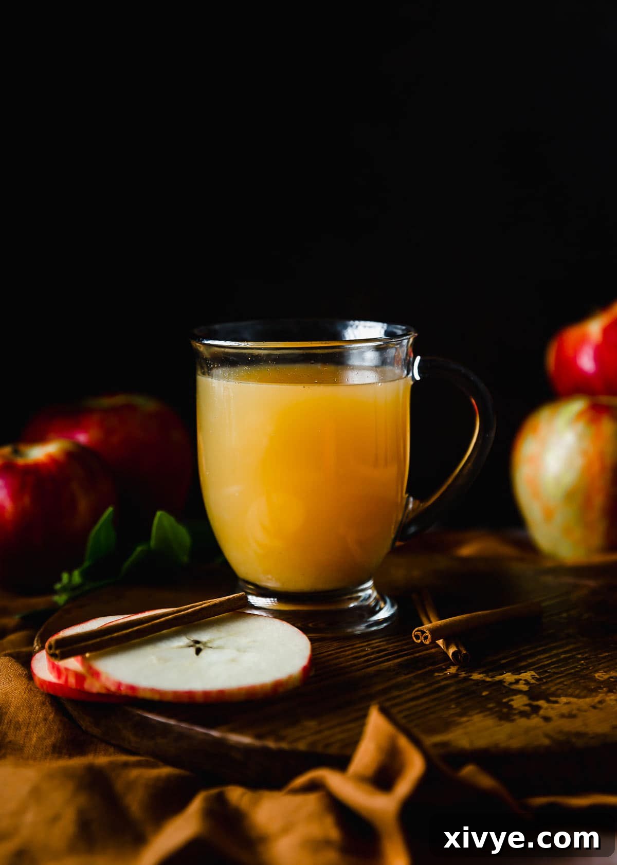 Hot Wassail in a clear mug against a black background.