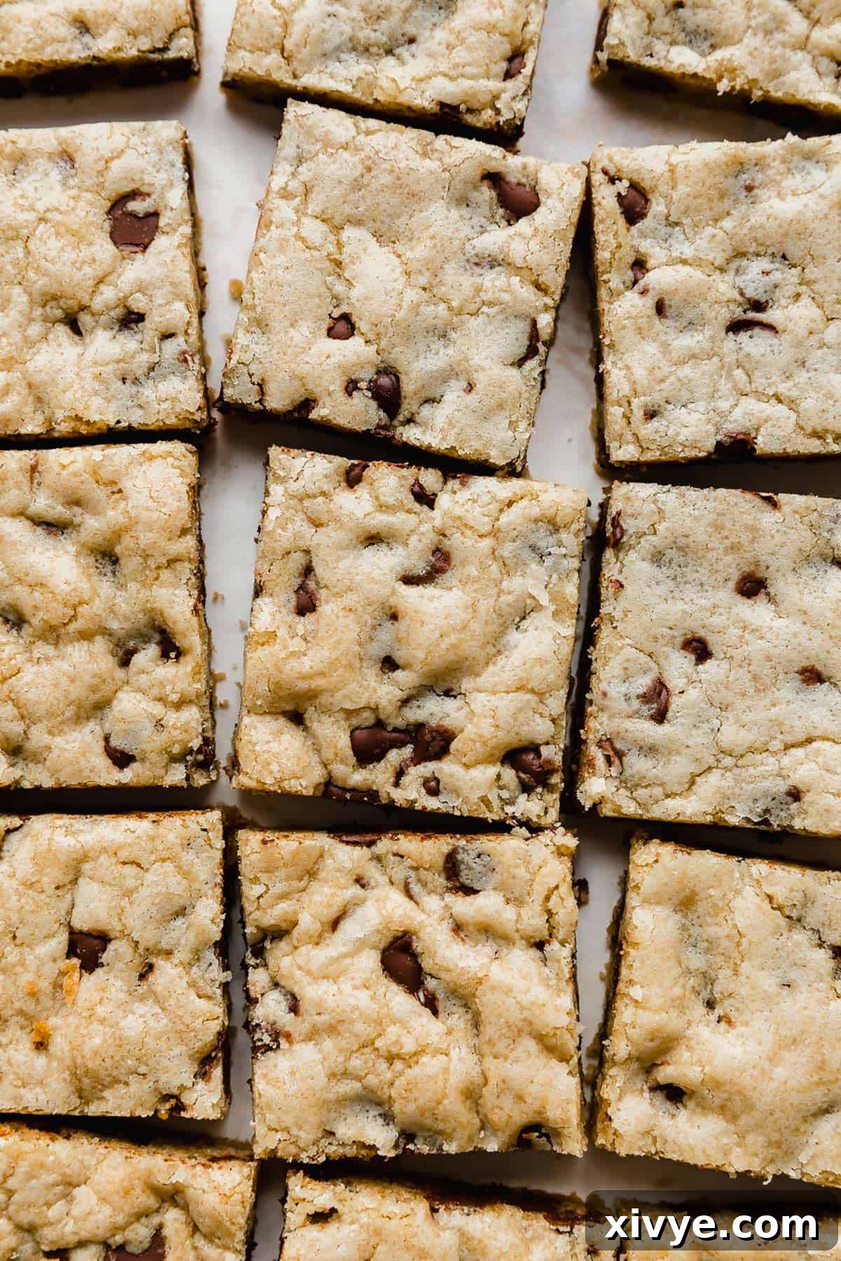 Chewy Chocolate Chip Cookie Bars lined up on a white background.