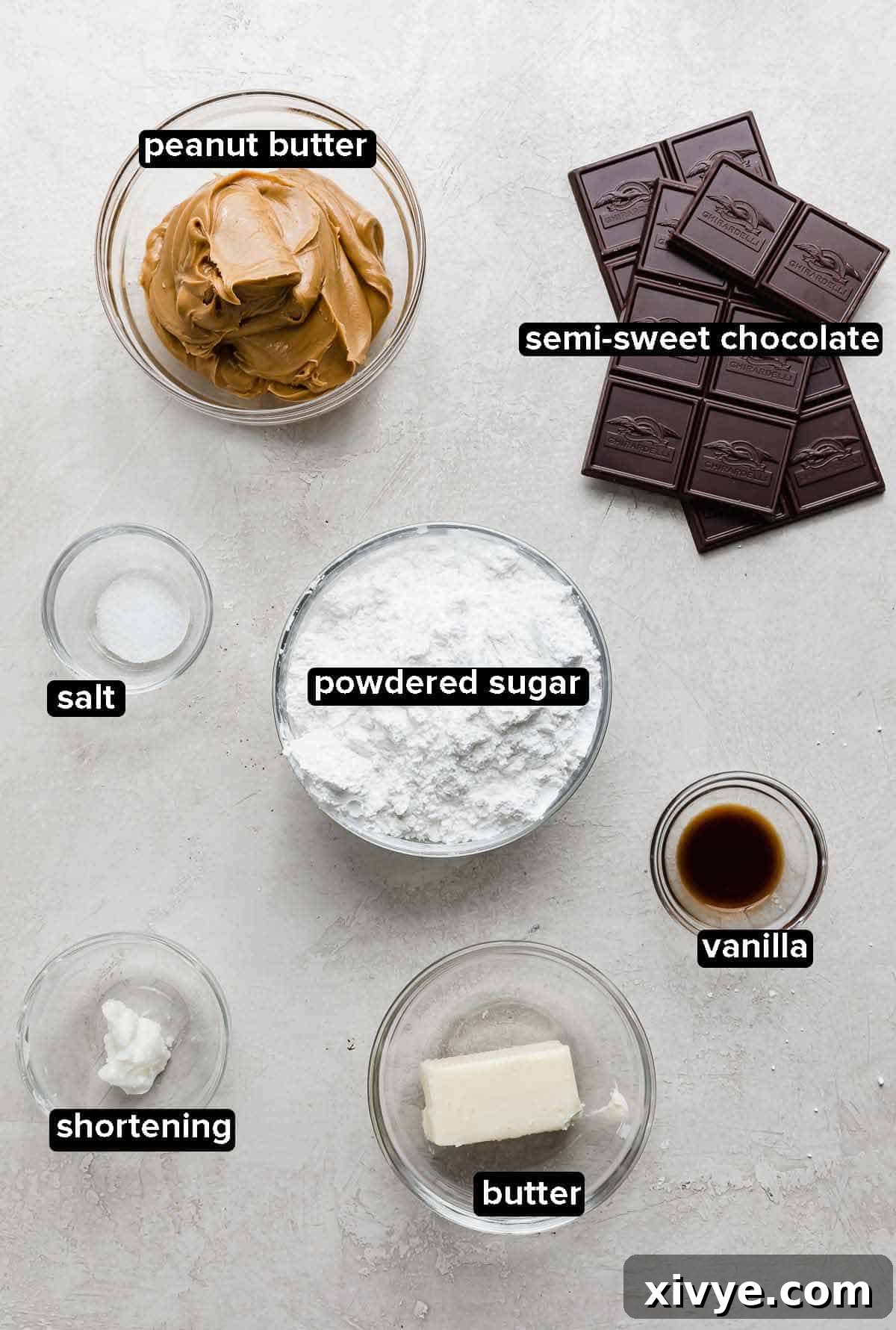Buckeyes recipe ingredients portioned into glass bowls on a gray background: butter, vanilla, shortening, powdered sugar, salt, peanut butter, and chocolate.
