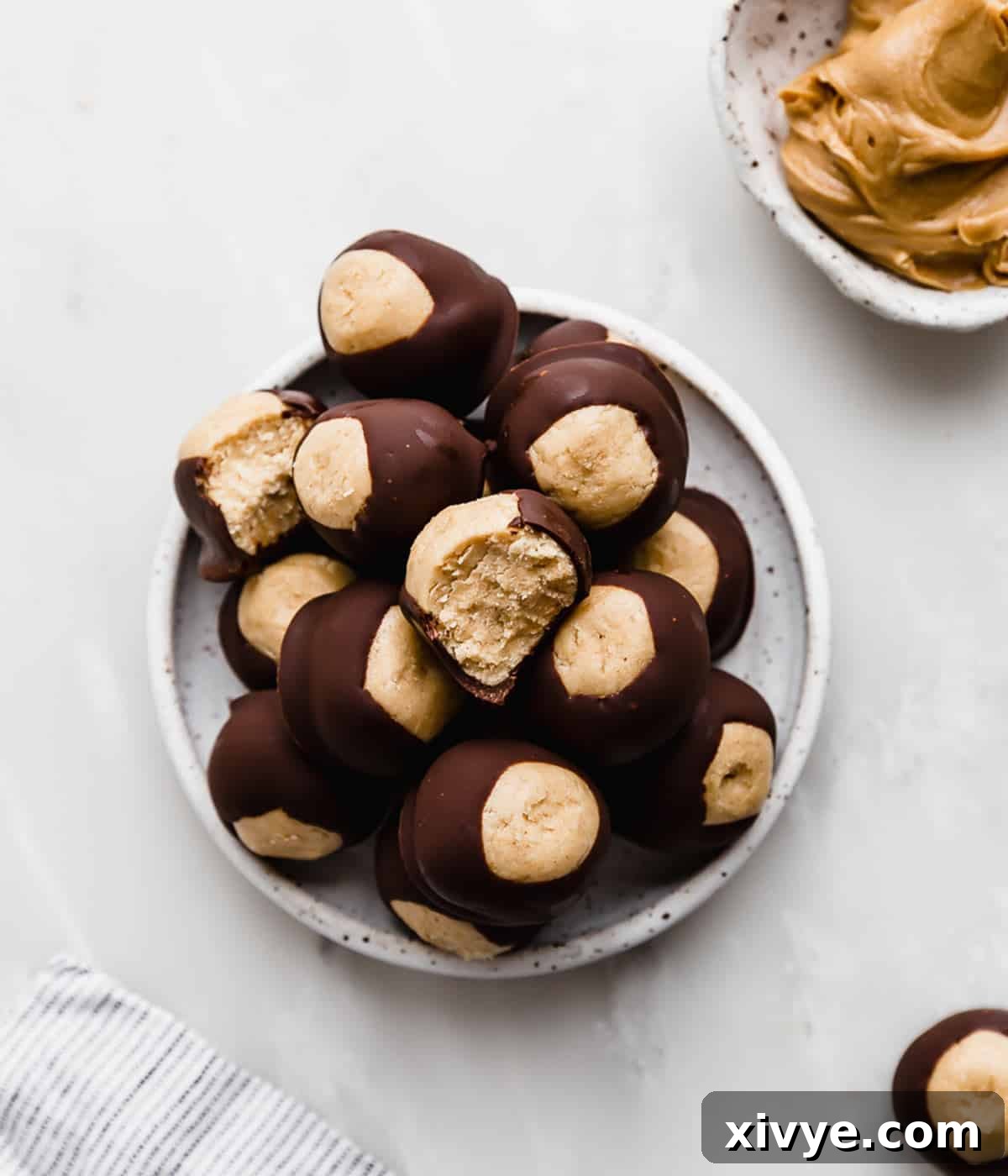 Buckeye balls on a white plate that's on a marble table.