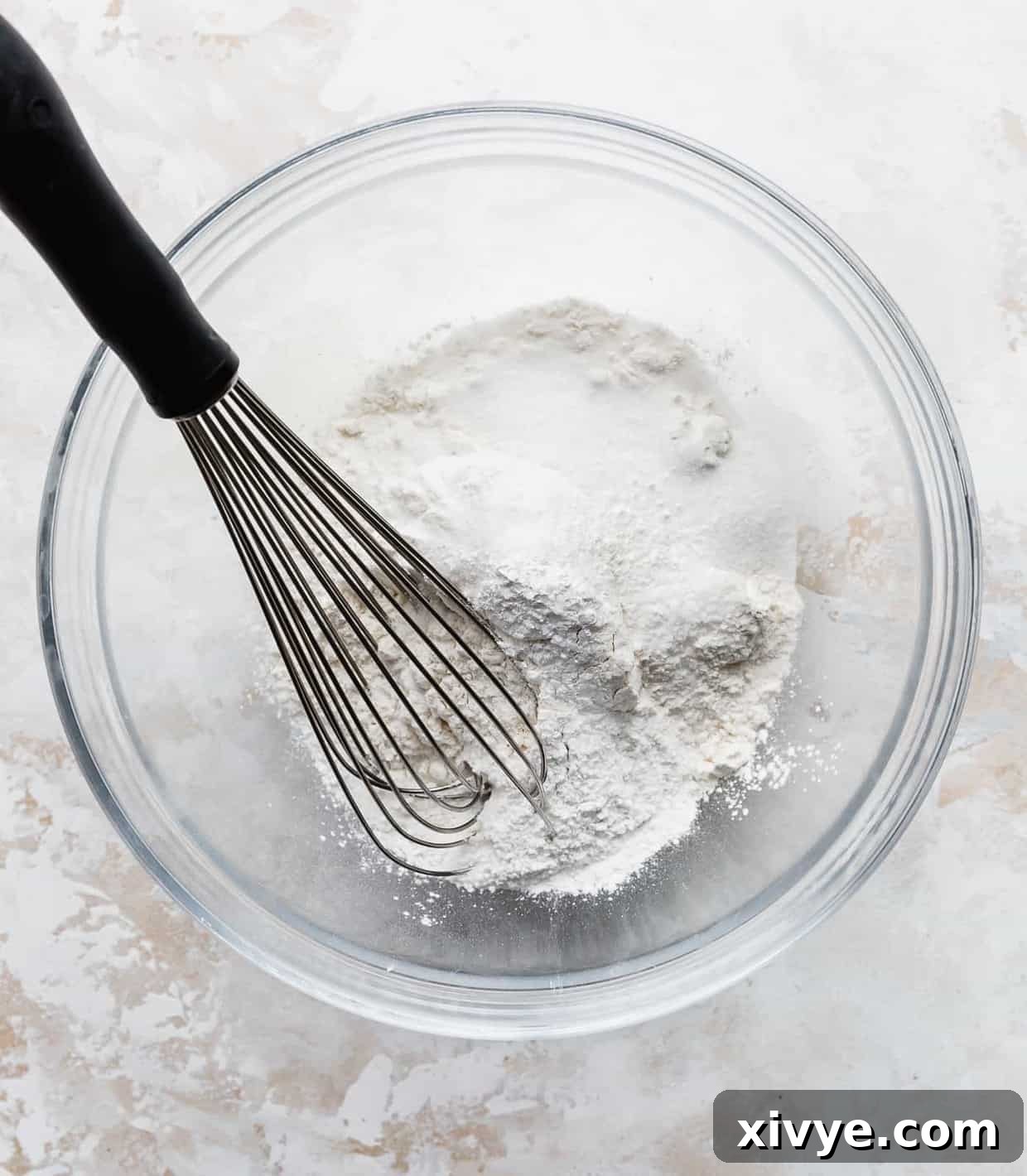 Japanese Soufflé Pancakes 4 White dry ingredients in a glass bowl against a white background.