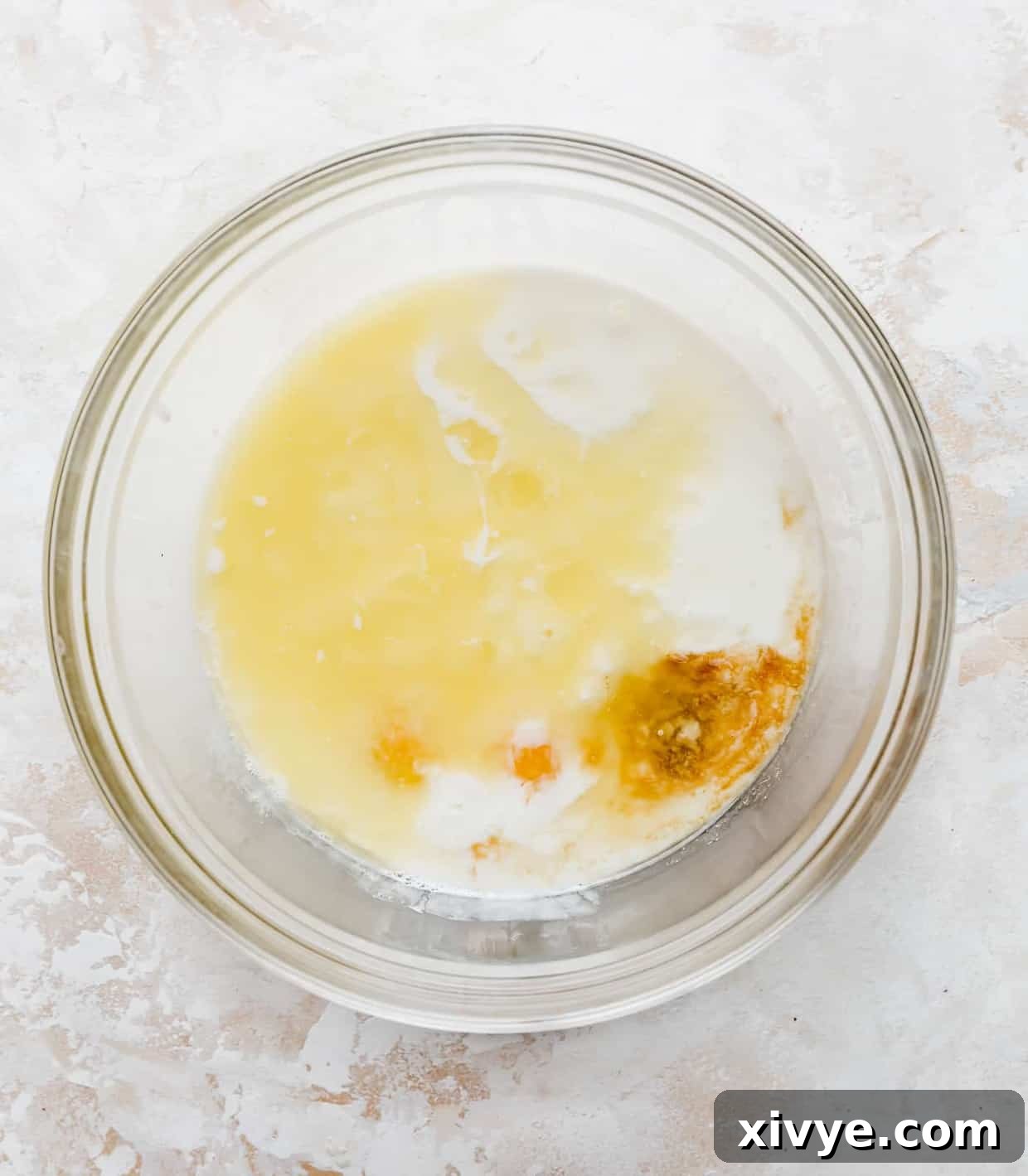 Japanese Soufflé Pancakes 5 A glass bowl full of buttermilk, melted butter, vanilla, and 2 egg yolks.