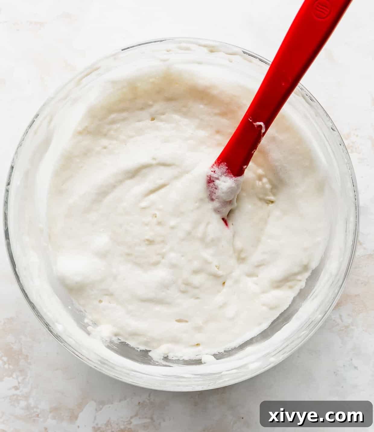 Japanese Soufflé Pancakes 6 Fluffy Japanese Pancake batter in a large glass bowl against a white background.