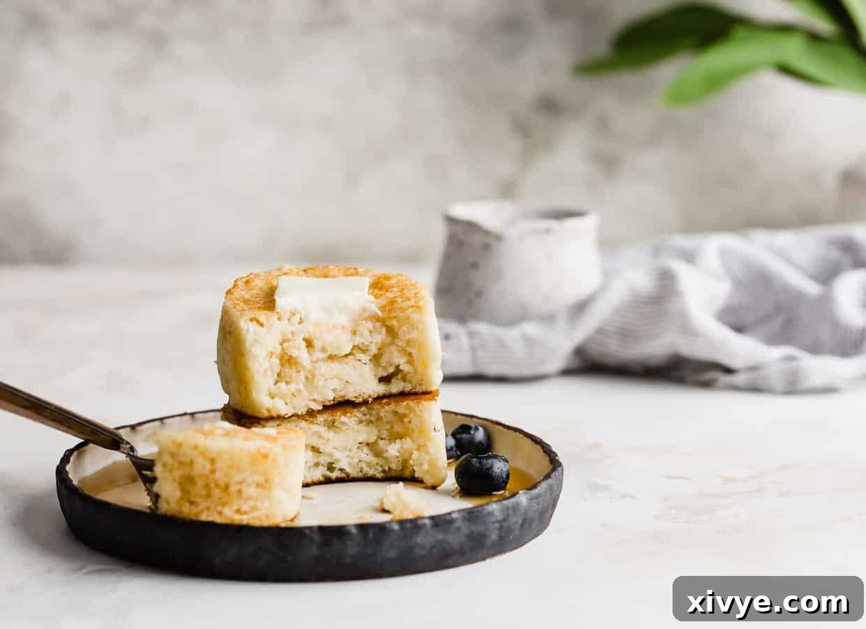 Japanese Soufflé Pancakes 7 Two Japanese pancakes on a plate, cut in half showing how fluffy they are.