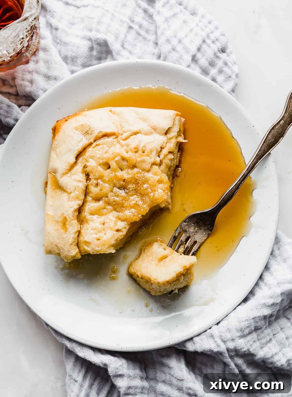 Wholesome German Pancake Delight 8 A syrup topped German pancake on a plate against a white background.