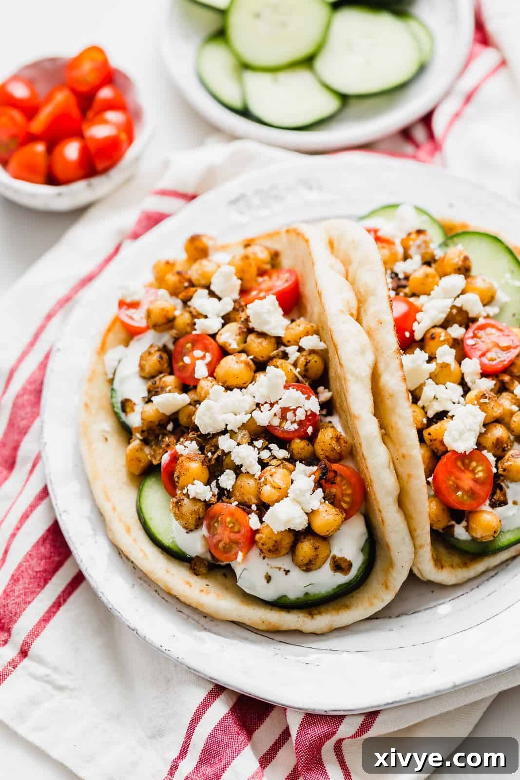 Kickstart Your Meals Week One 3 Two Chickpea Gyros on a white plate topped with cucumber, tomatoes, and feta cheese.