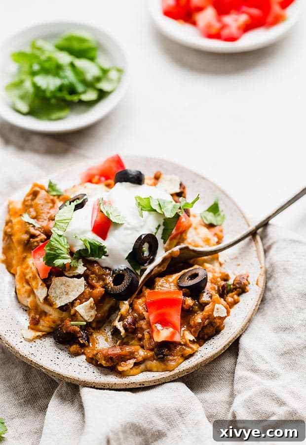 Kickstart Your Meals Week One 6 Mexican Lasagna topped with sour cream, cilantro, tomatoes, and olives.