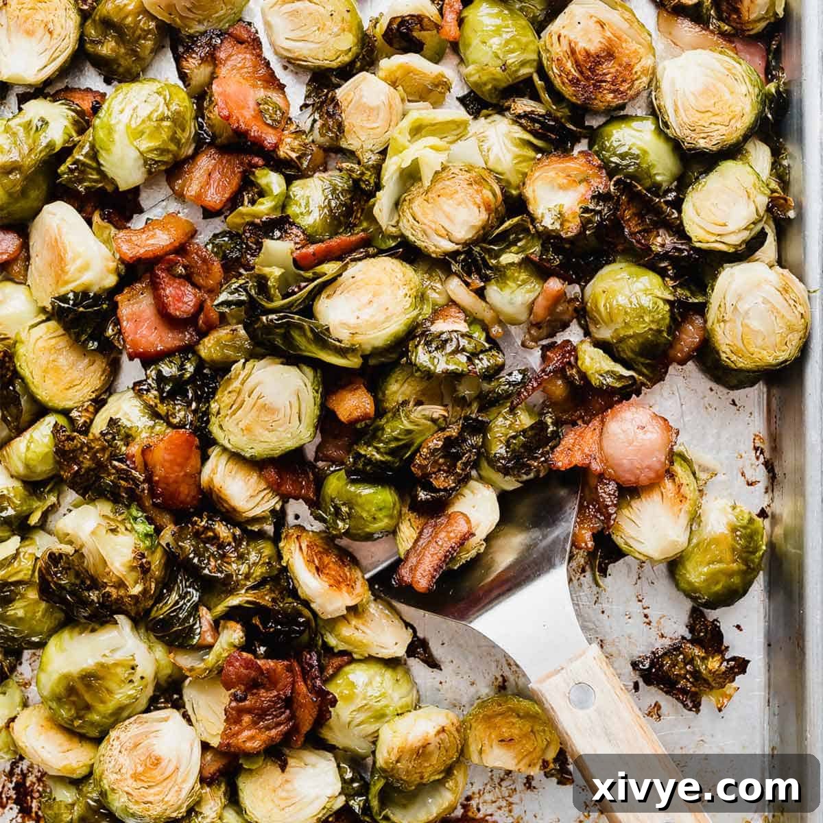A sheet pan with Roasted Brussels Sprouts with Bacon on it.