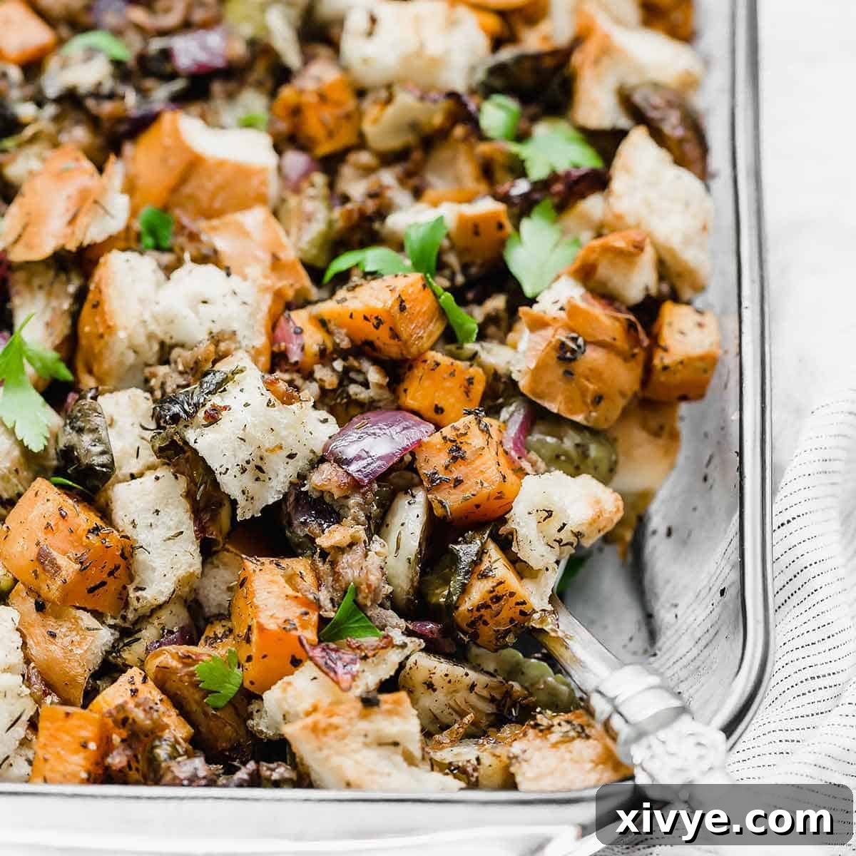Vegetable Stuffing in a glass baking dish, featuring purple onion, sweet potato, and Brussels sprouts.