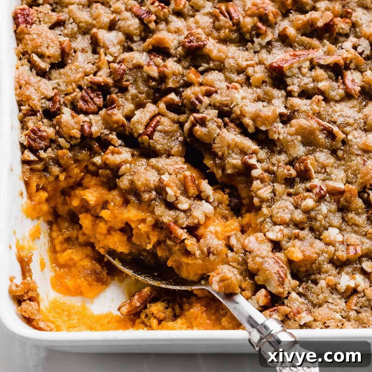 Sweet Potato Casserole topped with a pecan crust in a baking dish.