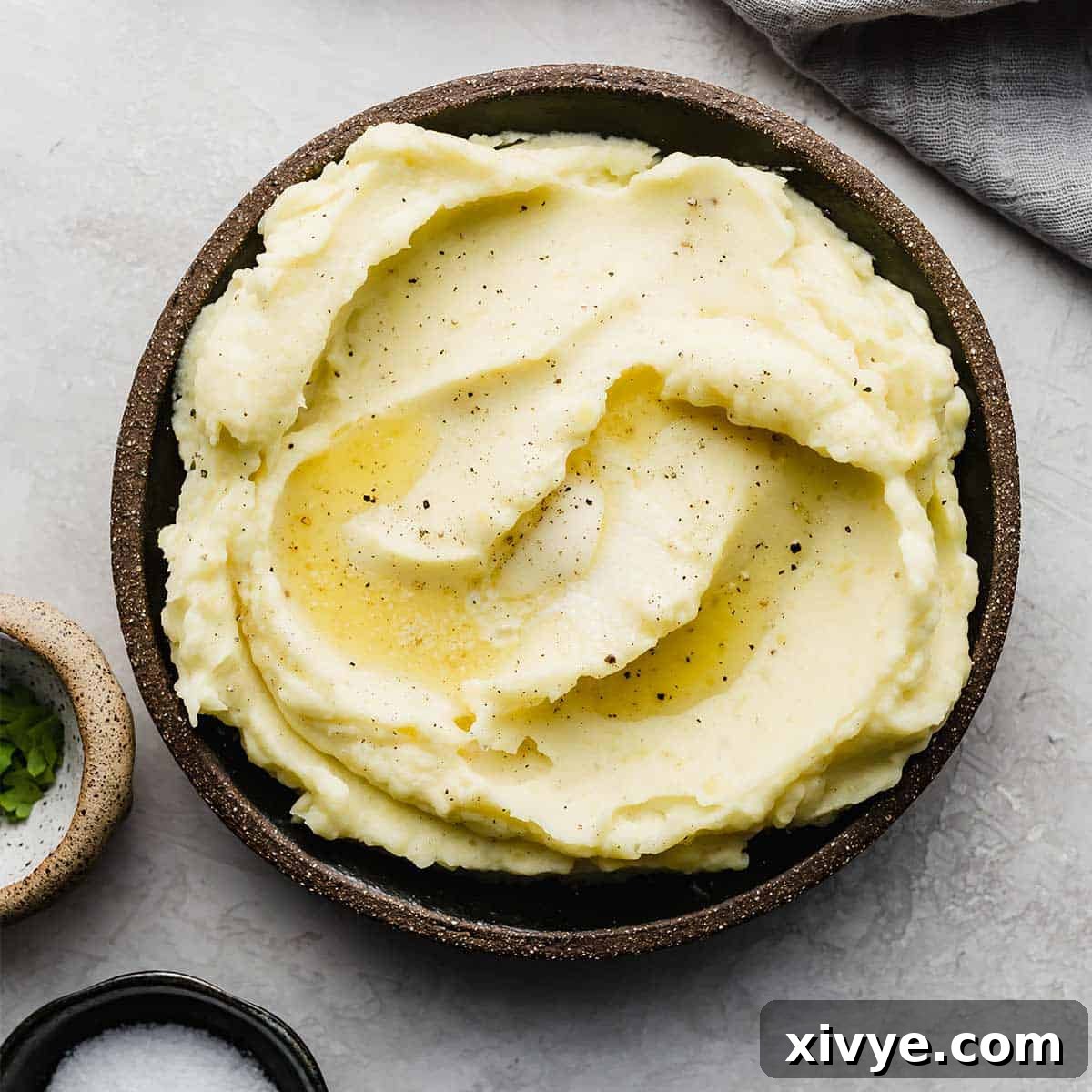 A black rimmed plate filled with Homemade Mashed Potatoes made with half and half and butter.