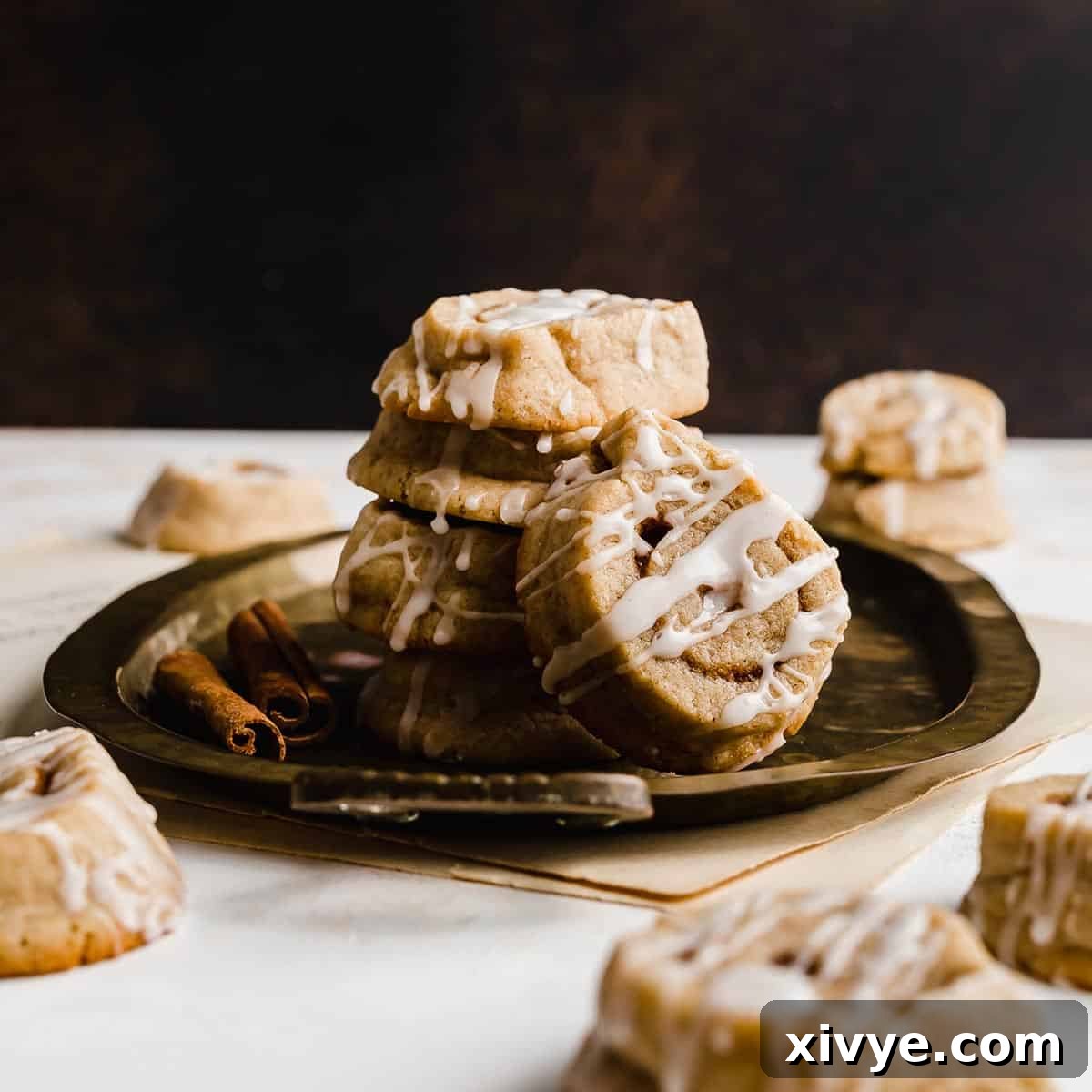 Festive Cookie Favorites Collection 21 Iced Cinnamon Roll Cookies against a brown background.