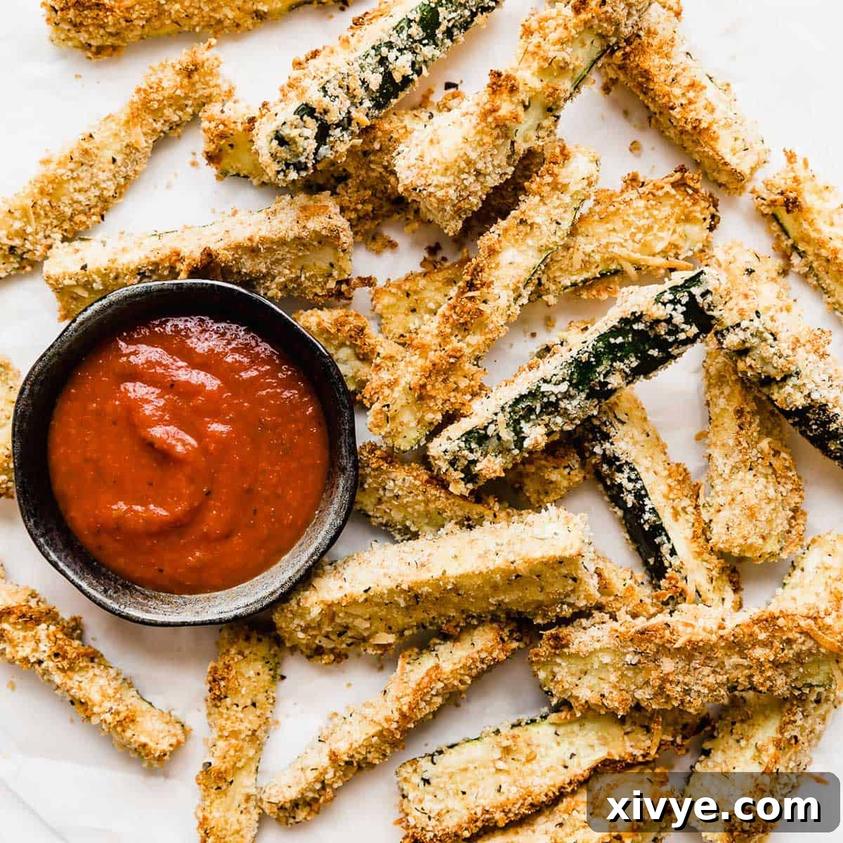 Crispy zucchini fries on a white plate.