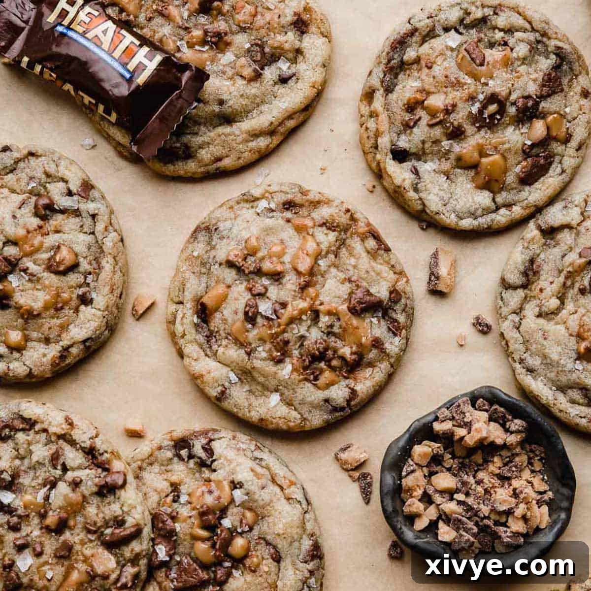Heath Bar Cookies topped with lots of Heath toffee bits, on a Kraft parchment paper.
