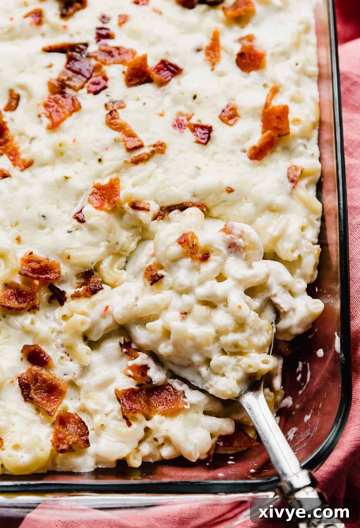 Spicy Pepper Jack Macaroni 2 A spoon scooping up bacon topped Mac and cheese.