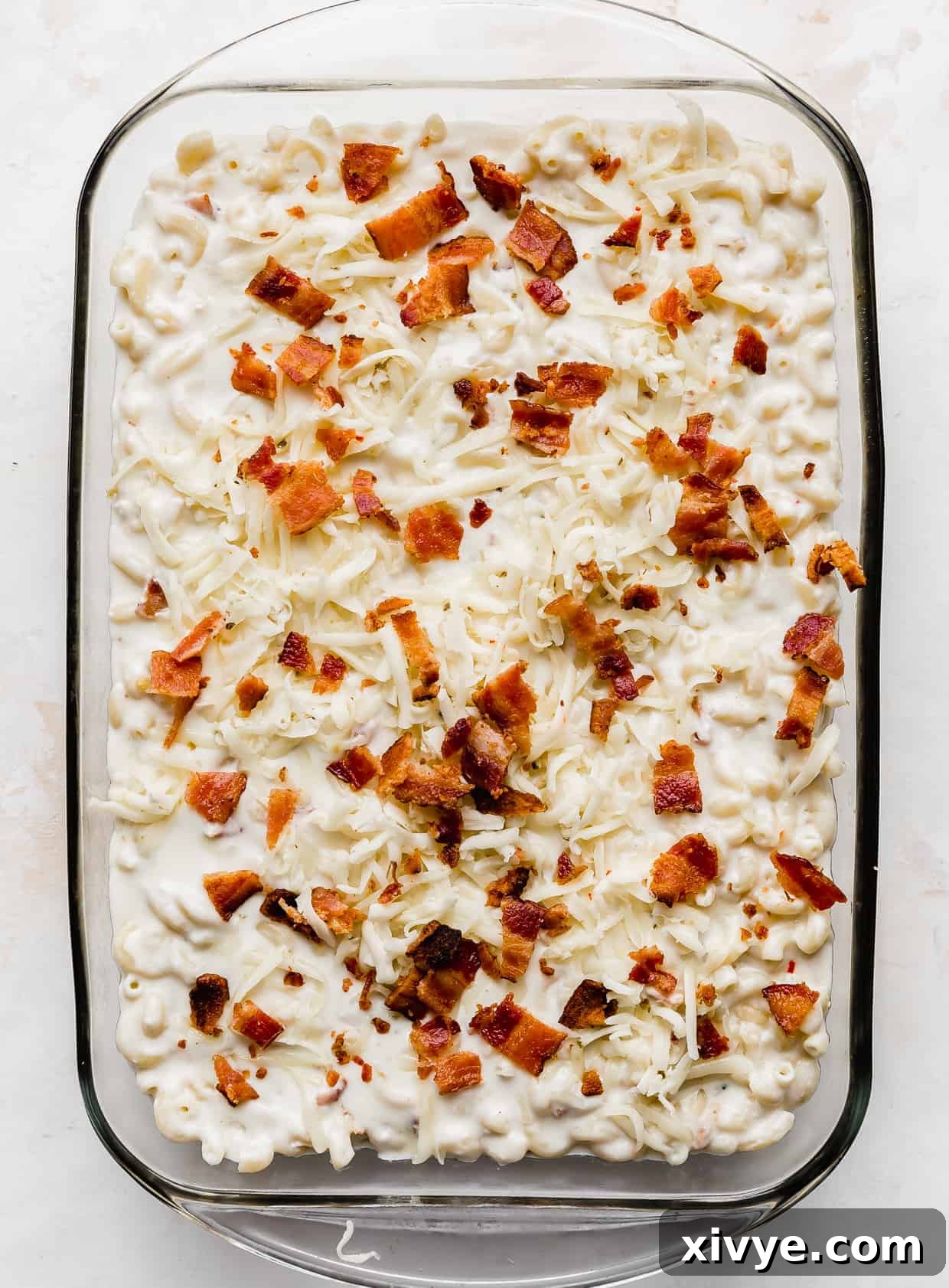 Spicy Pepper Jack Macaroni 7 A casserole dish with Bacon Pepper Jack Mac and Cheese in it against a white background.