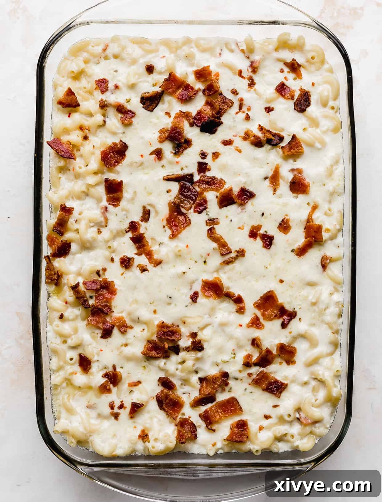 Spicy Pepper Jack Macaroni 8 Freshly baked Bacon Pepper Jack Mac and Cheese in a casserole dish against a white background.