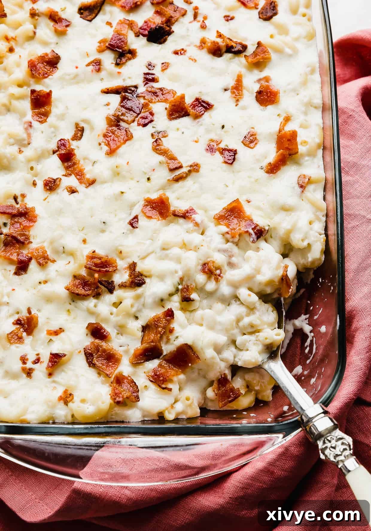 Spicy Pepper Jack Macaroni 9 A close up photo of a spoon scooping out cheesy bacon Mac and cheese.