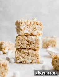 A stack of three Salted Brown Butter Rice Krispies Treats on top of each other.