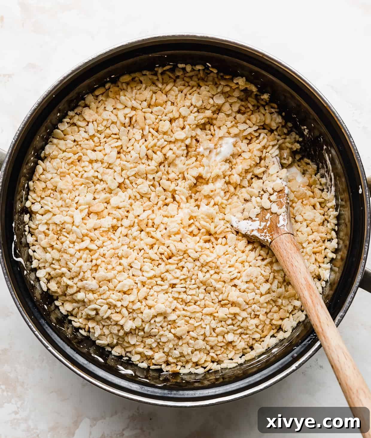 Rice Krispies cereal in a large black pot, against a white background.