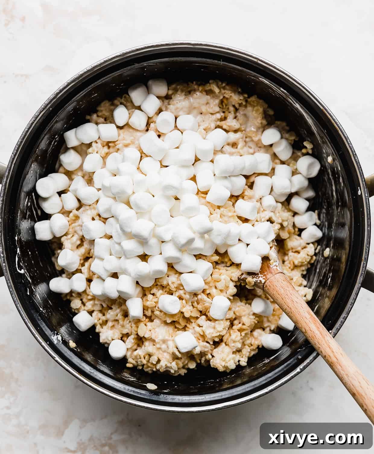 Mini marshmallows in a large pot, begin stirred into Rice Krispie treats.