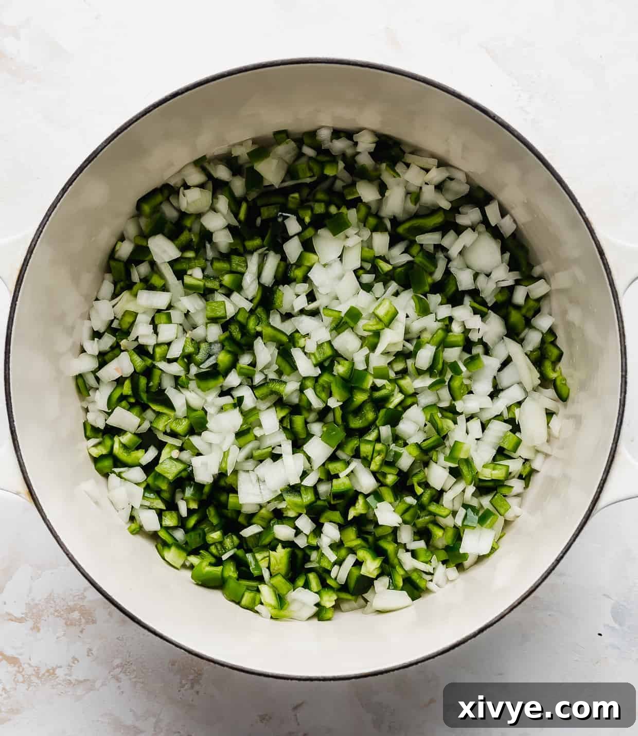 Creamy White Chicken Chili 4 A large pot filled with beautifully sautéed diced onions and various green peppers, creating a flavorful base for the chili.